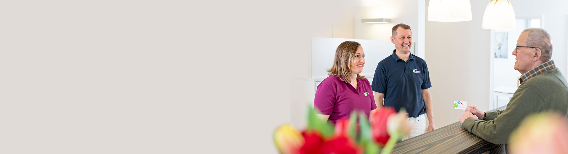 Unser Empfangsbereich mit unseren zwei Zahnärzten und einem Patienten.